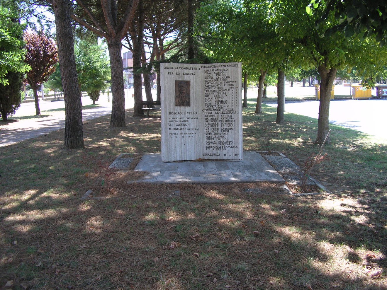 Monumento ai combattenti partigiani, in memoria dei caduti per la libertà, immerso in un'area alberata.