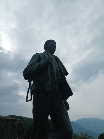 Monumento ai caduti, statua in bronzo che ritrae un soldato con un'espressione fiera, sullo sfondo nuvoloso.