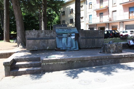 Monumento alla Resistenza antifascista, caratterizzato da una struttura in pietra e metallo, immerso nel verde urbano.