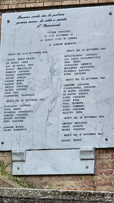 Monumento ai caduti, con iscrizioni commemorative in memoria dei soldati. Atmosfera solenne e di riflessione.