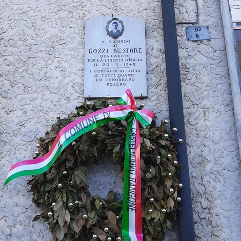 Lapide commemorativa con corona di fiori, dedicata a Gozzi Nestore per la libertà d’Italia.