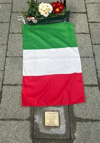 Pietra d'Inciampo a Ramella Pairin, coperta da un tricolore italiano e circondata da fiori.