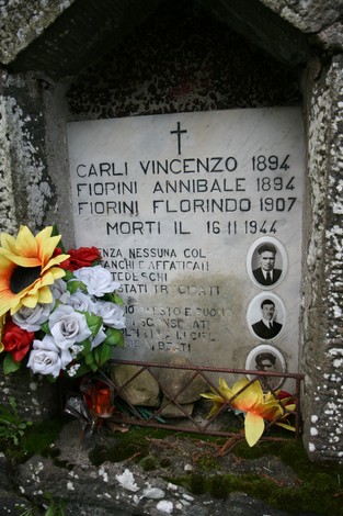 Tabernacolo commemorativo dedicate a Carli e Fiorini, con iscrizioni e adornato di fiori.