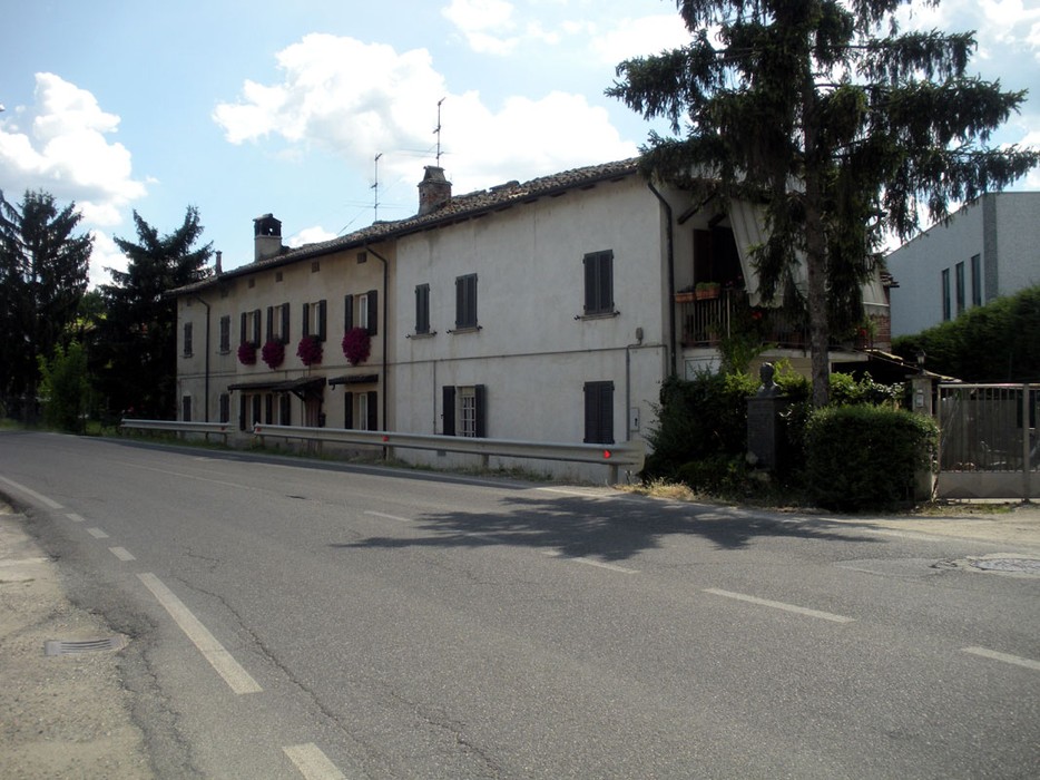 Monumento a Barni: edificio storico con giardini e fioriere, immerso nel paesaggio naturale circostante.