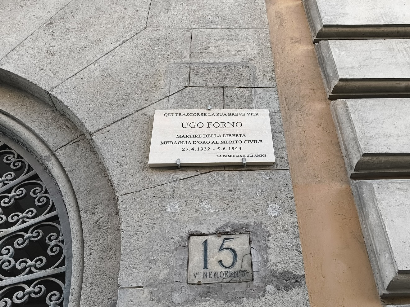 Lapide commemorativa di Ugo Forno, martire della libertà, situata in un edificio storico.