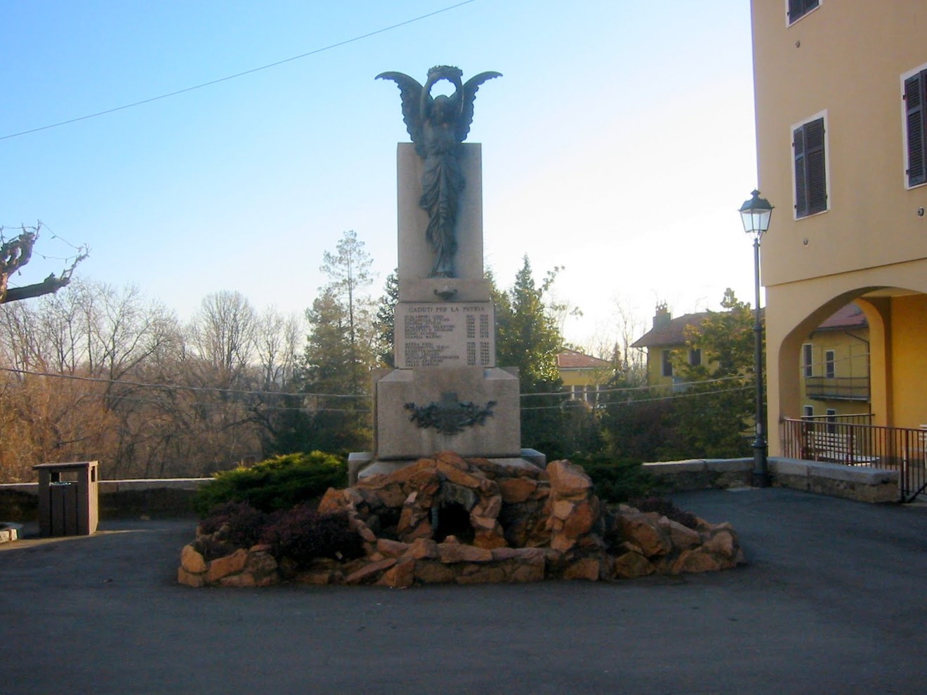 Monumento ai caduti di Casapinta, dedicato ai soldati che hanno perso la vita in guerra, circondato da un paesaggio sereno.