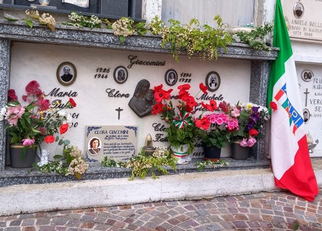 Sepolcro di Giacomini, decorato con fiori, foto e drappo tricolore, commemorativo di una famiglia.
