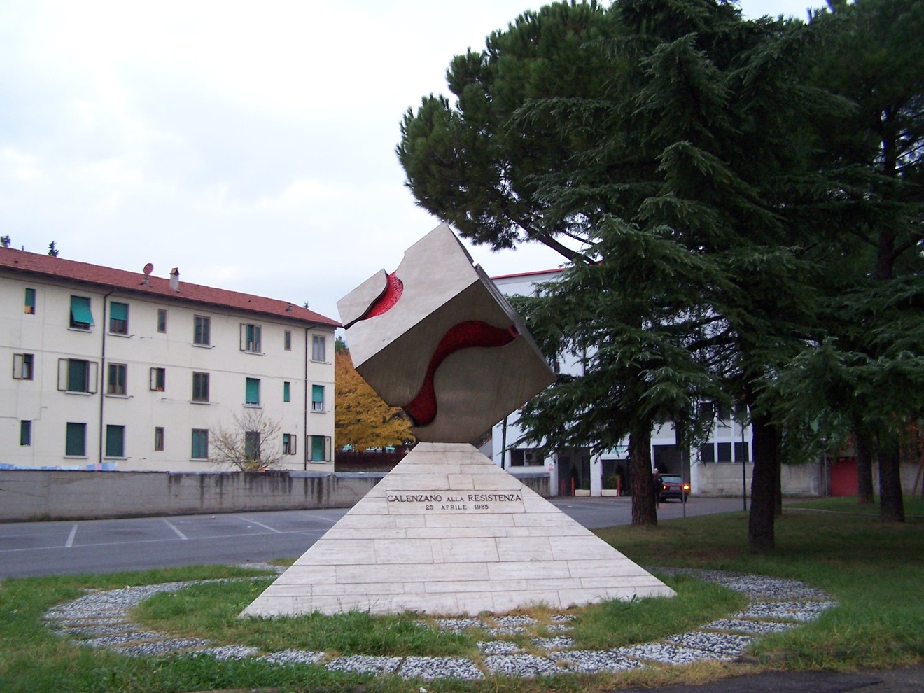 Monumento del quarantennale, scultura commemorativa circondata da alberi e edificio, simbolo di resistenza.