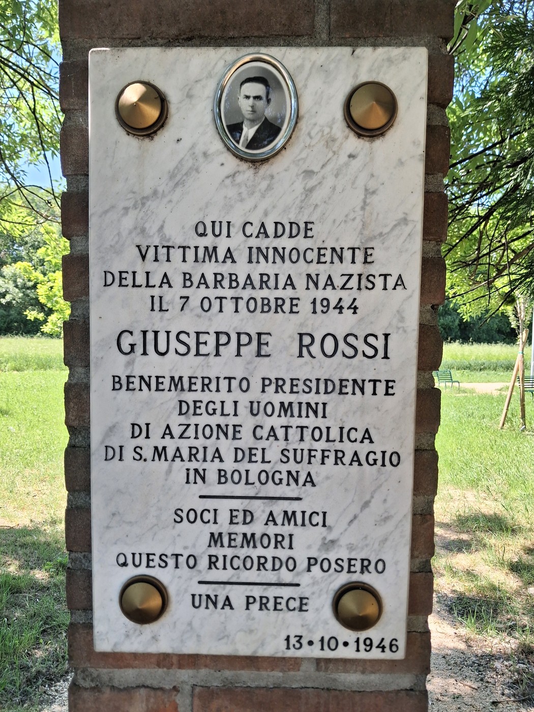 Cippo commemorativo dedicato a Giuseppe Rossi, vittima della barbarie nazista, con foto e iscrizioni memoriali.