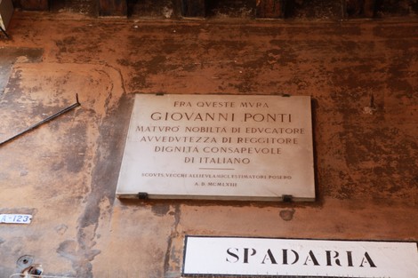 Lapide commemorativa dedicata a Giovanni Ponti, visibile in un ambiente storico. Mostra onore e riconoscimento.