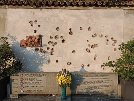 Monumento in memoria dei caduti del 18 marzo 1945, con simboli di commemorazione e omaggio floreale.