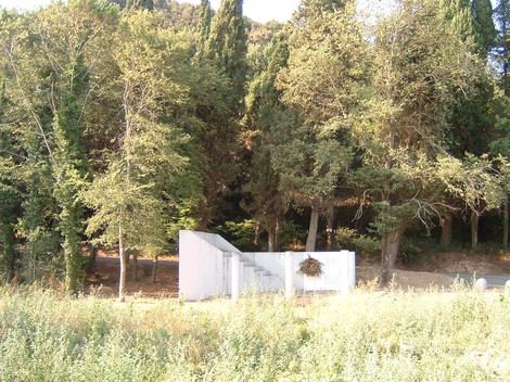Monumento di Nugola Vecchia, immerso nel verde, con una struttura bianca tra gli alberi.