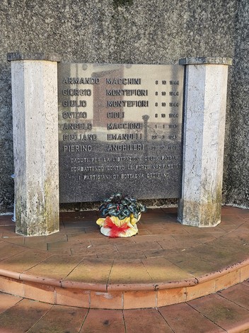 Monumento ai Caduti per la Libertà di Bottagna, con nomi incisi su una lapide e fiori ai piedi.