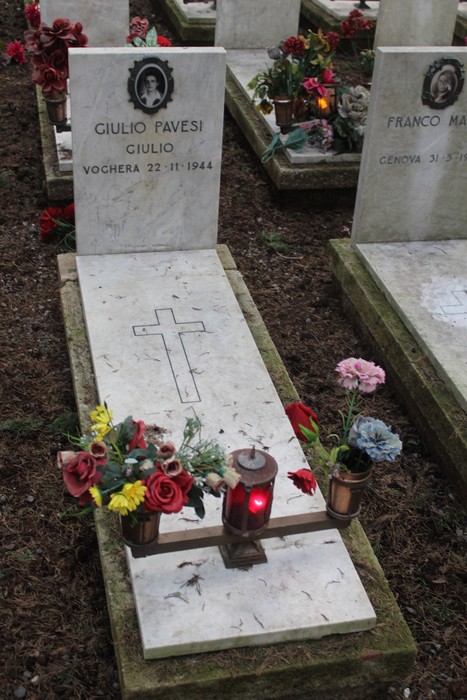 Tombe con fiori e candele, in memoria dei caduti per la Libertà, simbolo di rispetto e commemorazione.