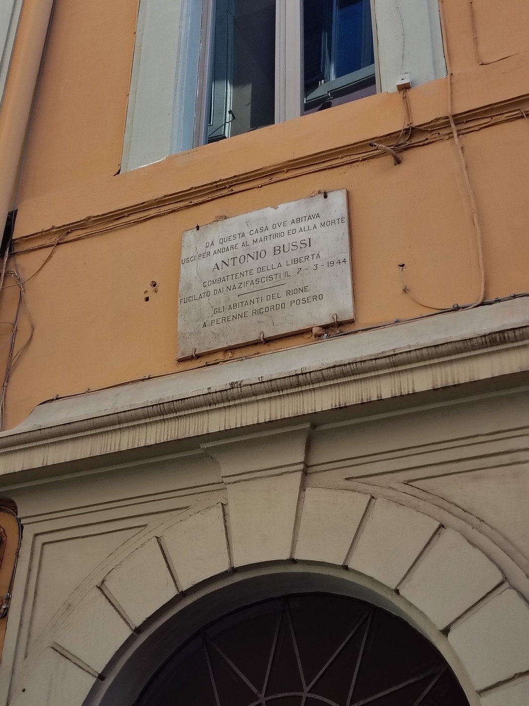 Lapide commemorativa dedicata ad Antonio Bussi, situata su un edificio storico.