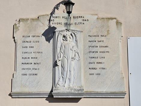 Lapide commemorativa dedicata ai caduti della guerra 1940-1945, con nomi incisi e un angelo in rilievo.