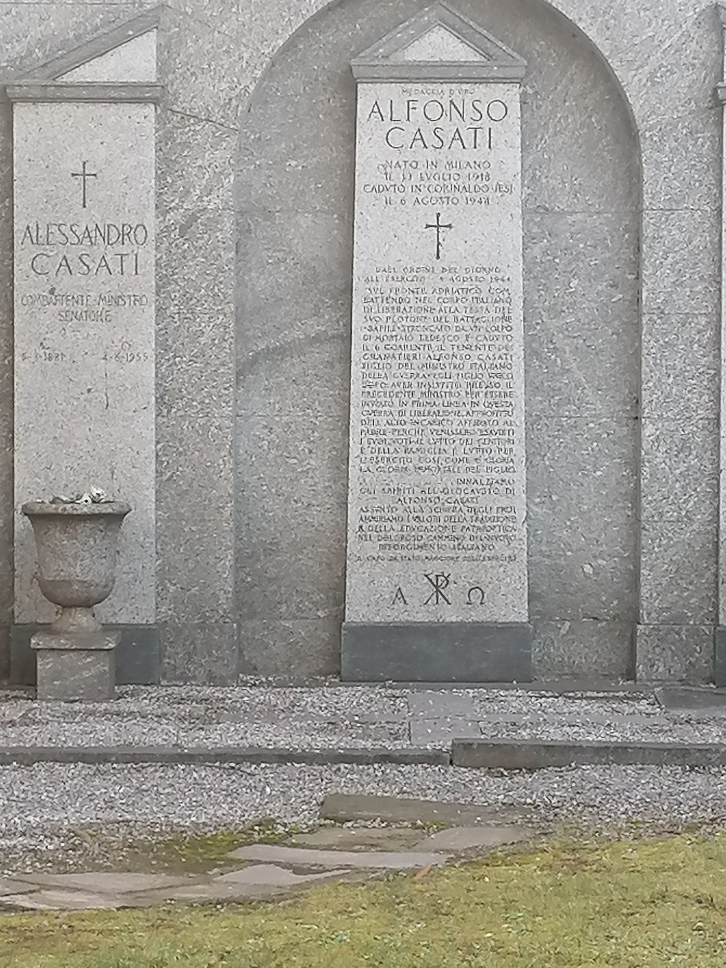 Mausoleo Casati con lastre di pietra decorate e iscrizioni, circondato da un prato curato.
