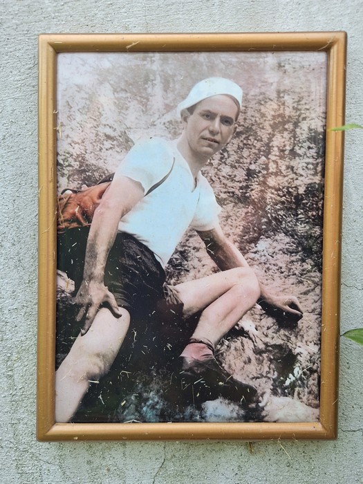 Cippo commemorativo dedicato a Pillot, con fotografia vintage di un uomo in abbigliamento d'epoca su sfondo naturale.