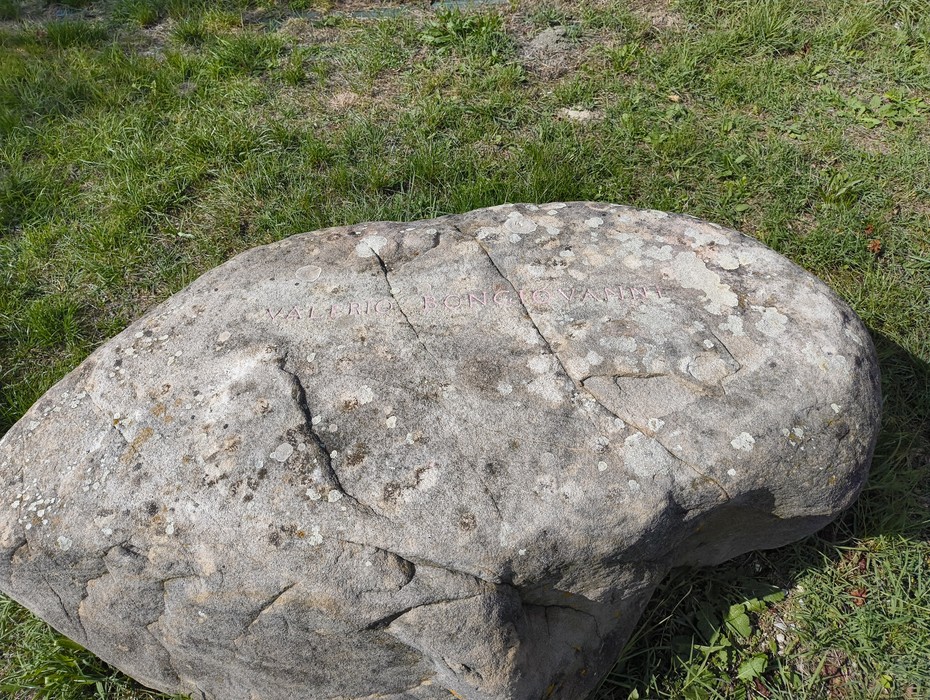 Monumento ai partigiani caduti a Monte Sabbiuno, pietra commemorativa immersa nel verde.