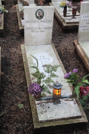Tombe perpetue con fiori e lumini in onore dei caduti per la Libertà in un cimitero.