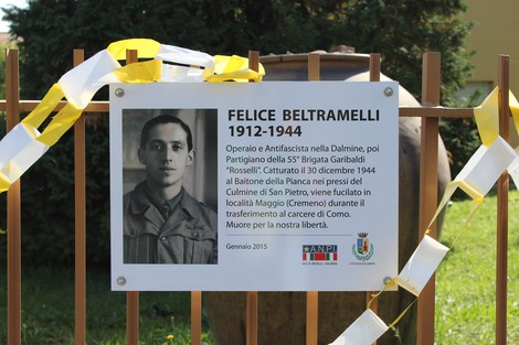 Targa commemorativa dedicata a Felice Beltramelli, partigiano della Brigata Garibaldi, in un ambiente naturale.
