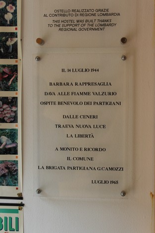 Targa commemorativa dell'incendio di Valzurio, che onora la resistenza partigiana e la libertà.