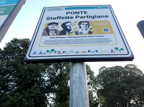 Targa commemorativa del Ponte Staffette Partigiane con immagini e informazioni su Lidia Menapace, Giuseppina Priola e Maria Codezzi.