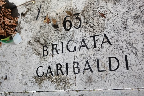 Monumento commemorativo in onore della 63° Brigata Garibaldi, con dettagli in pietra e foglie secche.