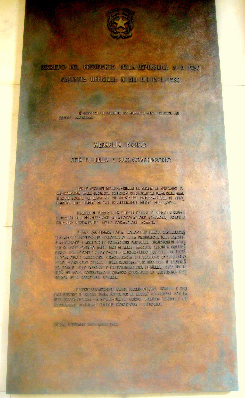 Targa commemorativa in bronzo che celebra la medaglia d'oro, simbolo di onore e valore.