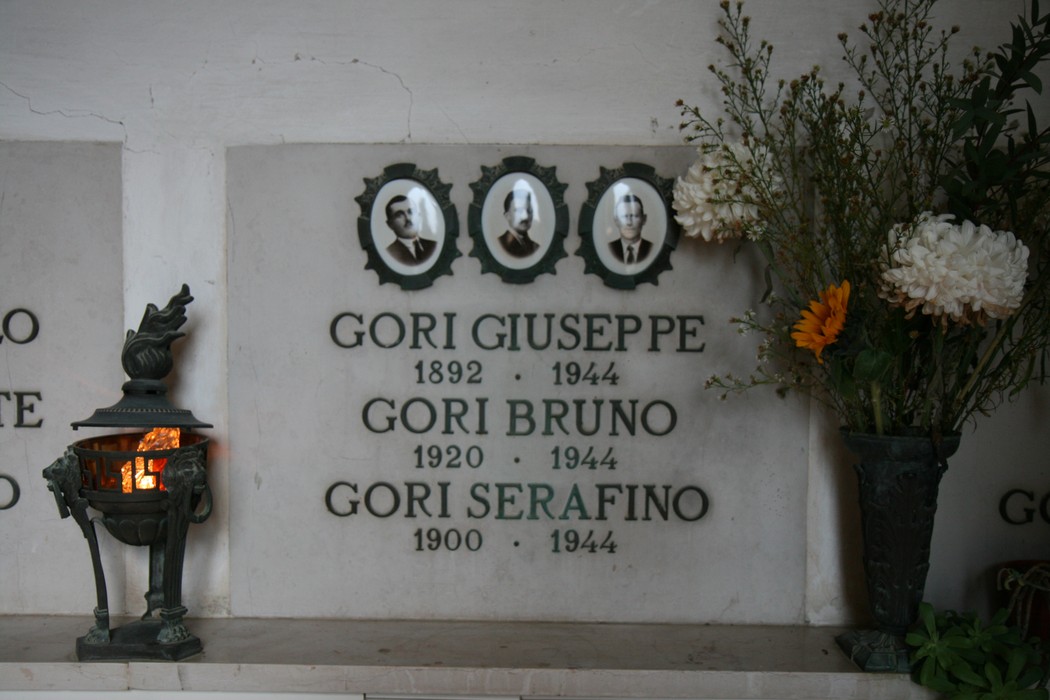 Sepolcro delle vittime dell'eccidio di Pratale, con fotografie e omaggi floreali in memoria.