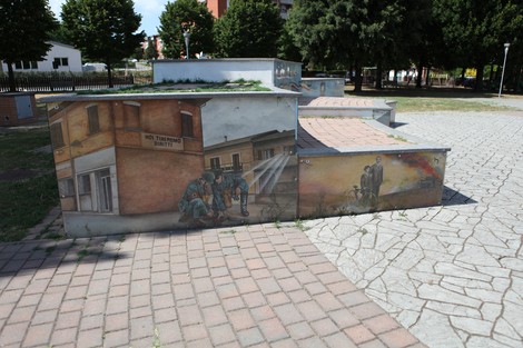 Murali colorati nel parco della Liberazione, rappresentanti scene storiche e comunitarie, tra natura e arte urbana.