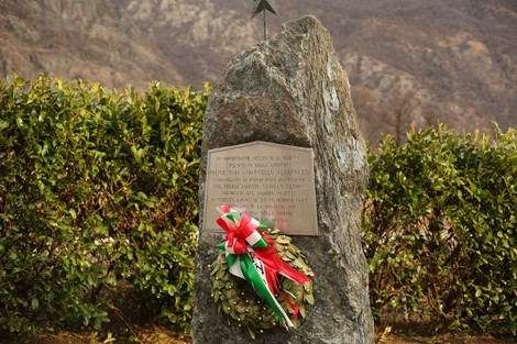 Monumento commemorativo a Cima, dedicato a Albertazzi e Altieri, circondato da vegetazione.