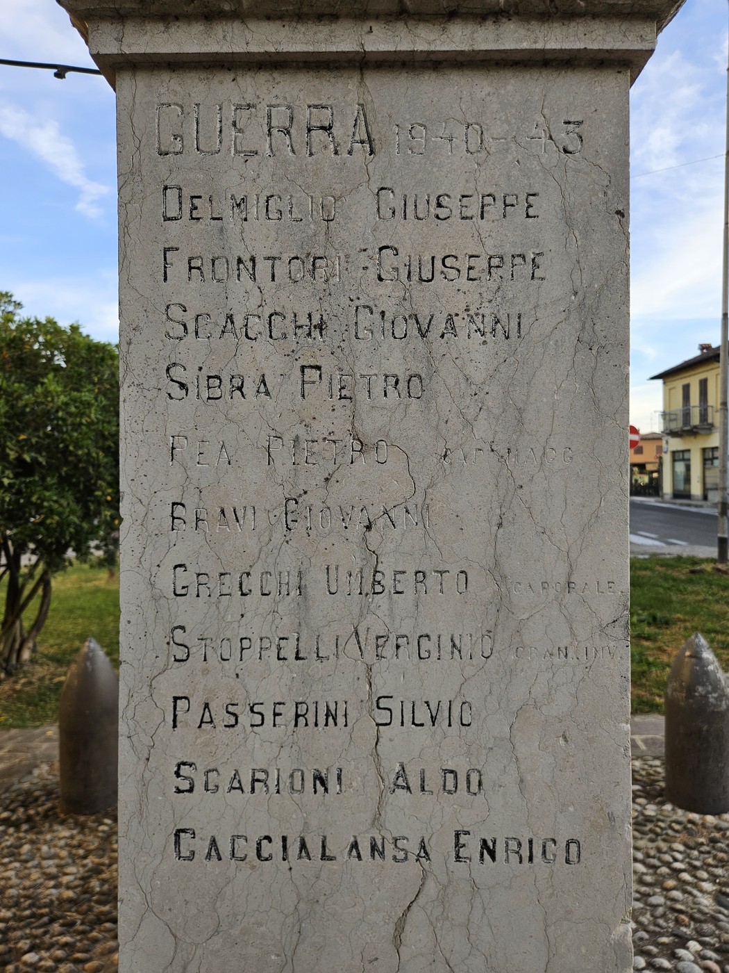 Monumento in pietra con lapide incisa recante elenco di nomi, collocato all'aperto su basamento.