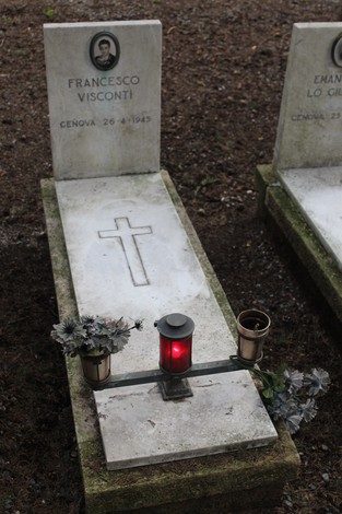 Tombe monumentali con croce e lumino rosso in memoria dei caduti per la libertà.
