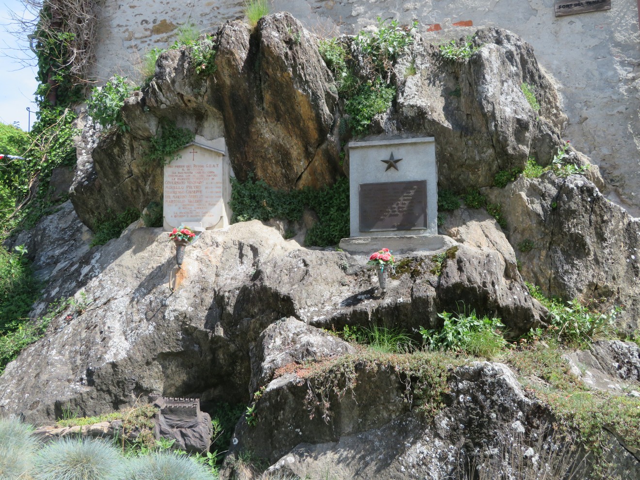 Cippi commemorativi ai caduti del rifugio GEAT e alla Brigata Carli, posizionati su una roccia.