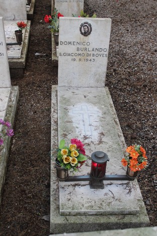 Tomba con epitafio di Domenico Burlando, decorata con fiori e una lanterna, in memoria dei caduti per la libertà.