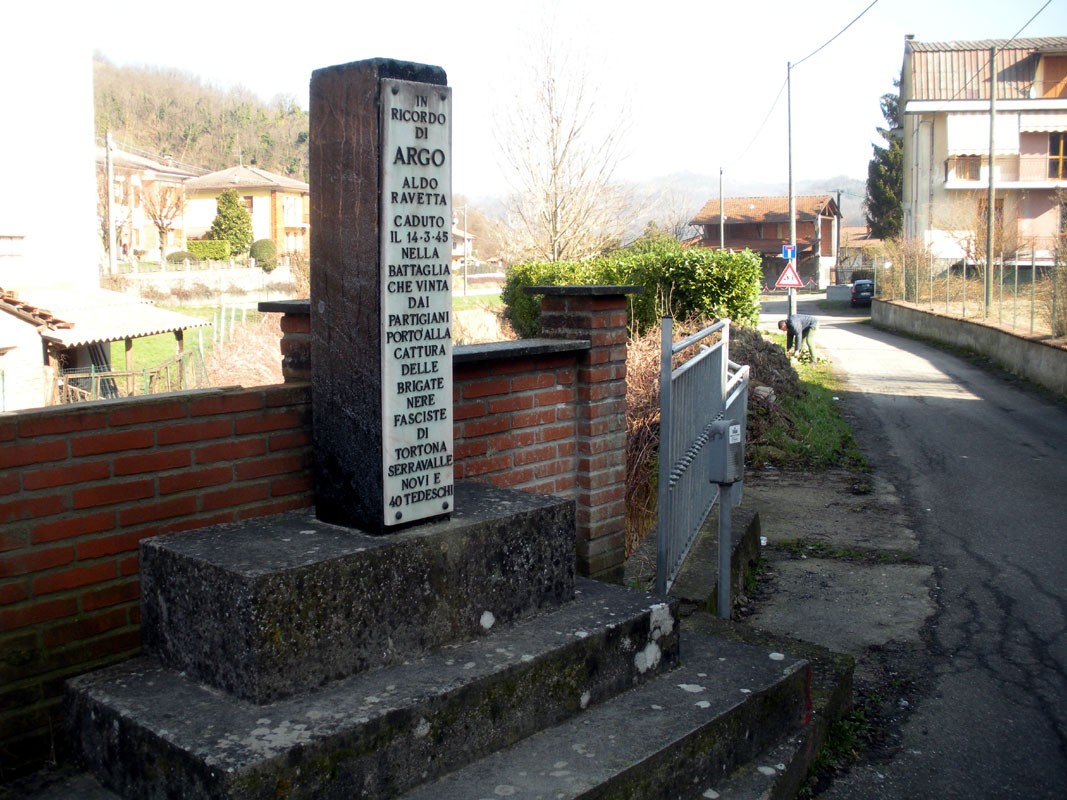 Cippo commemorativo a Ravetta, dedicato ai caduti della Seconda Guerra Mondiale, immerso nel paesaggio rurale.