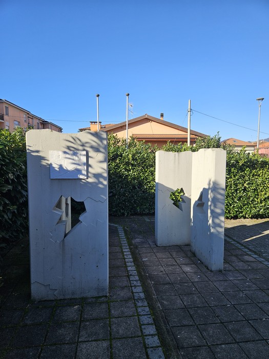 Monumento alla Resistenza con forme geometriche bianche immerse nel verde di un giardino urbano.
