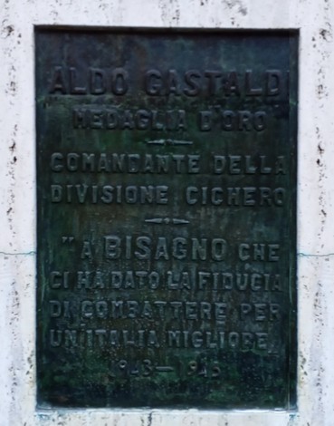 Monumento commemorativo a Gastaldi, in marmo, con iscrizioni dedicate al comandante e alla sua storia.