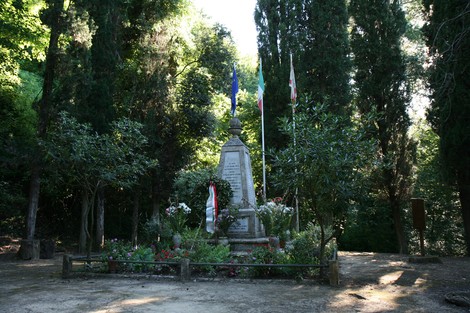 Monumento dedicato alle vittime dell'eccidio di Guardistallo e Montescudaio, immerso nella natura.