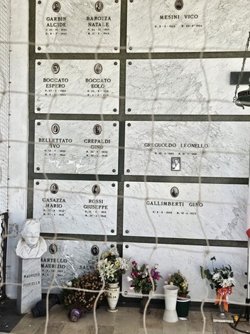 Sacrario dei Partigiani con lapidi, fiori e un busto, in un ambiente sobrio e commemorativo.