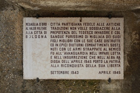 Monumento Ossario dei caduti partigiani con iscrizioni commemorative e decorazioni, simbolo di resistenza e storia.