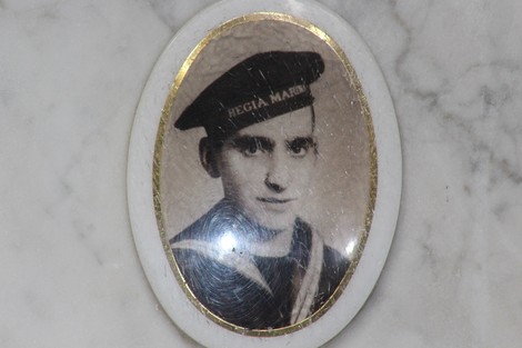 Ritratto in bianco e nero di un marinario, incorniciato in un medaglione, su sfondo marmoreo.