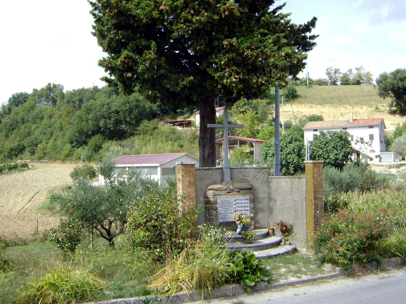 Monumento commemorativo dedicato ai Caduti dell'eccidio di Montalvello, immerso nella natura circostante.