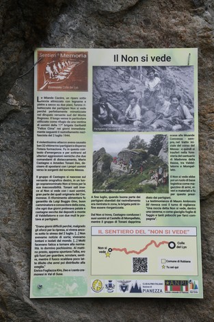 Fotografia del rifugio partigiano "Non si vede", con un gruppo di persone in un paesaggio montano.