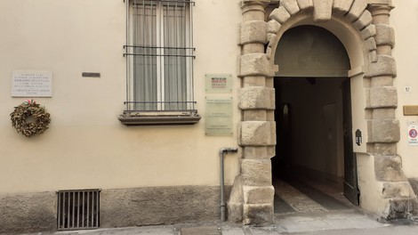 Lapide commemorativa a Ruscello, incastonata in un elegante edificio storico con ingresso architettonico.
