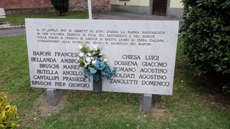 Lapide commemorativa per i caduti dell'eccidio, con fiori e nomi incisi in memoria dei martiri.