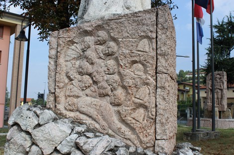 Dettaglio del basamento del Monumento alla Resistenza, con rilievi che rappresentano figure simboliche e storiche.