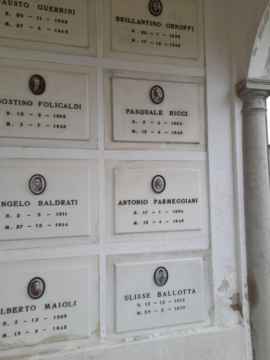 Monumento commemorativo ai partigiani, con medaglioni e nomi dei caduti in esposizione.