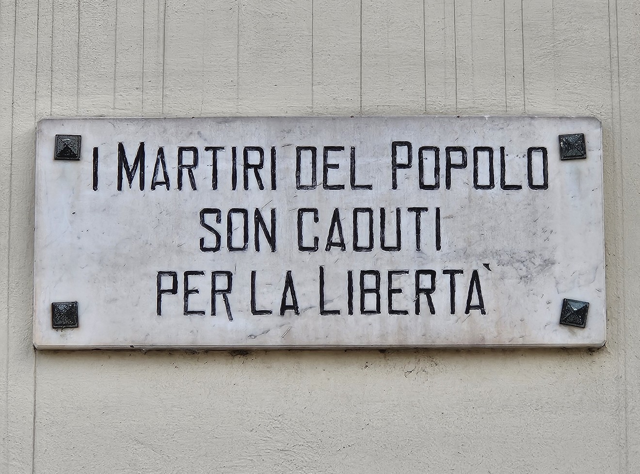 Lapide commemorativa che onora i Martiri del Popolo, simbolo di lotta per la libertà.